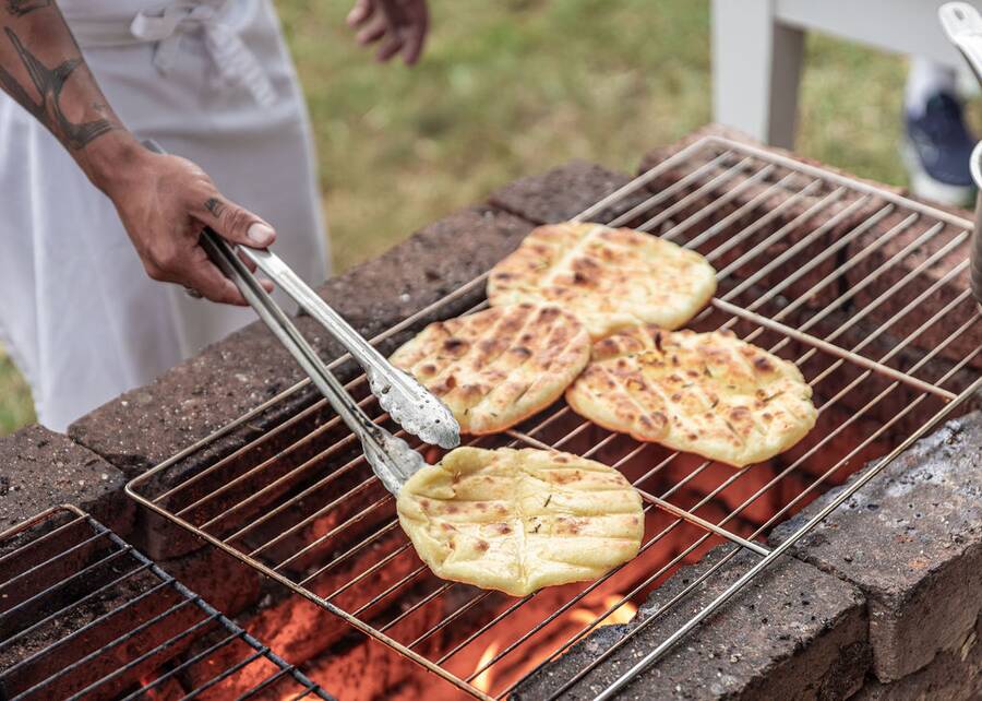 Flatbreads cooking over the open-fire parrilla at a cooking class